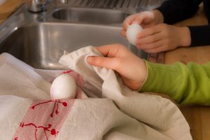 Zwei Kinder trocknen Eierschalen ab.