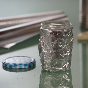 Eine Aluminiumfolie ist um ein Marmeladenglas gewickelt.