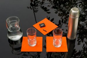 Eine Karaffe mit Wasser, zwei Gläser und eine Thermoskanne stehen auf einem Tisch.