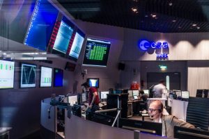 Im Kontrollraum der ESA sitzen Wissenschaftler vor einer Vielzahl von Bildschirmen. Sie wachen über Satelliten.