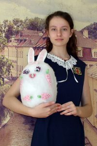 Ein Foto von dem Mädchen Jana Swistunowa aus Russland. Es zeigt sie selbst und ein großes Osterei aus Stoff.
