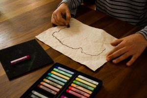Ein Junge zeichnet eine Karte auf ein zerknittertes Stück Papier.