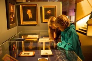 Zwei Kinder schauen sich ein altes Buch im Gutenberg Museum an.
