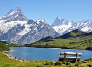 Eine Alm in den Alpen mit einem See im Sommer.