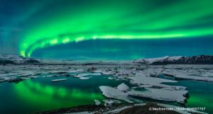 Polarlichter schweben über einer nächtlichen, dunklen Polarlandschaft in Jokulsarlon in Island.
