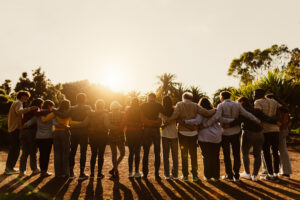 Rückansicht von glücklichen Mehrgenerationenmenschen, die sich bei Sonnenuntergang in einem öffentlichen Park vergnügen - Gemeinschafts- und Unterstützungskonzept